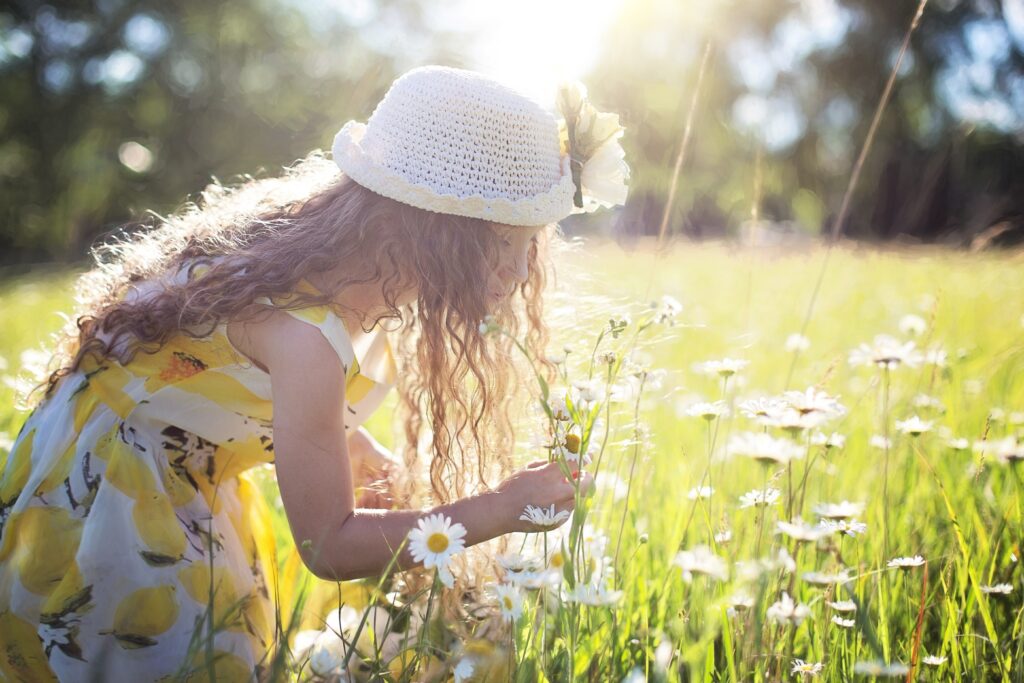 Child enjoying flowers in the sun, getting natural vitamin D
